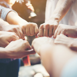 Close up of young people putting their hands together. Team with