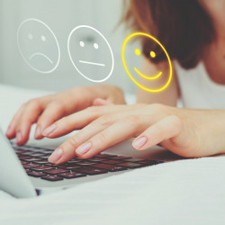 Good mood concept made of emoticon and rating. The girl puts grades on the Internet using a laptop.